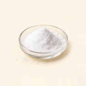 Alpha-arbutin: fine white crystalline powder in a glass dish