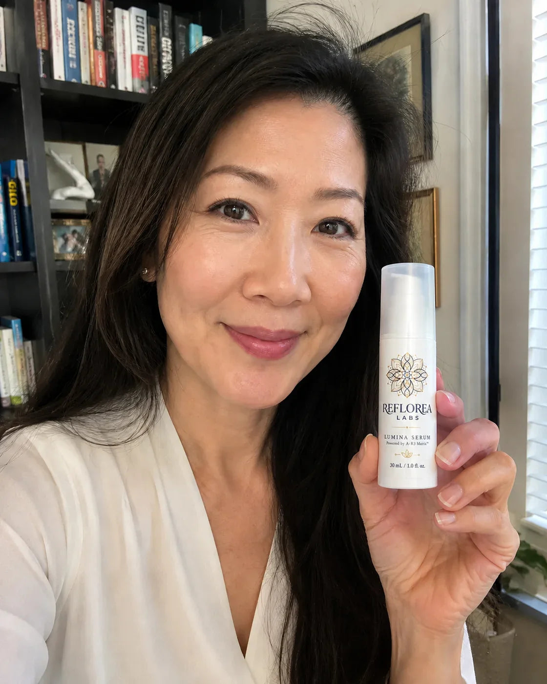 Woman holding the Lumina Serum bottle