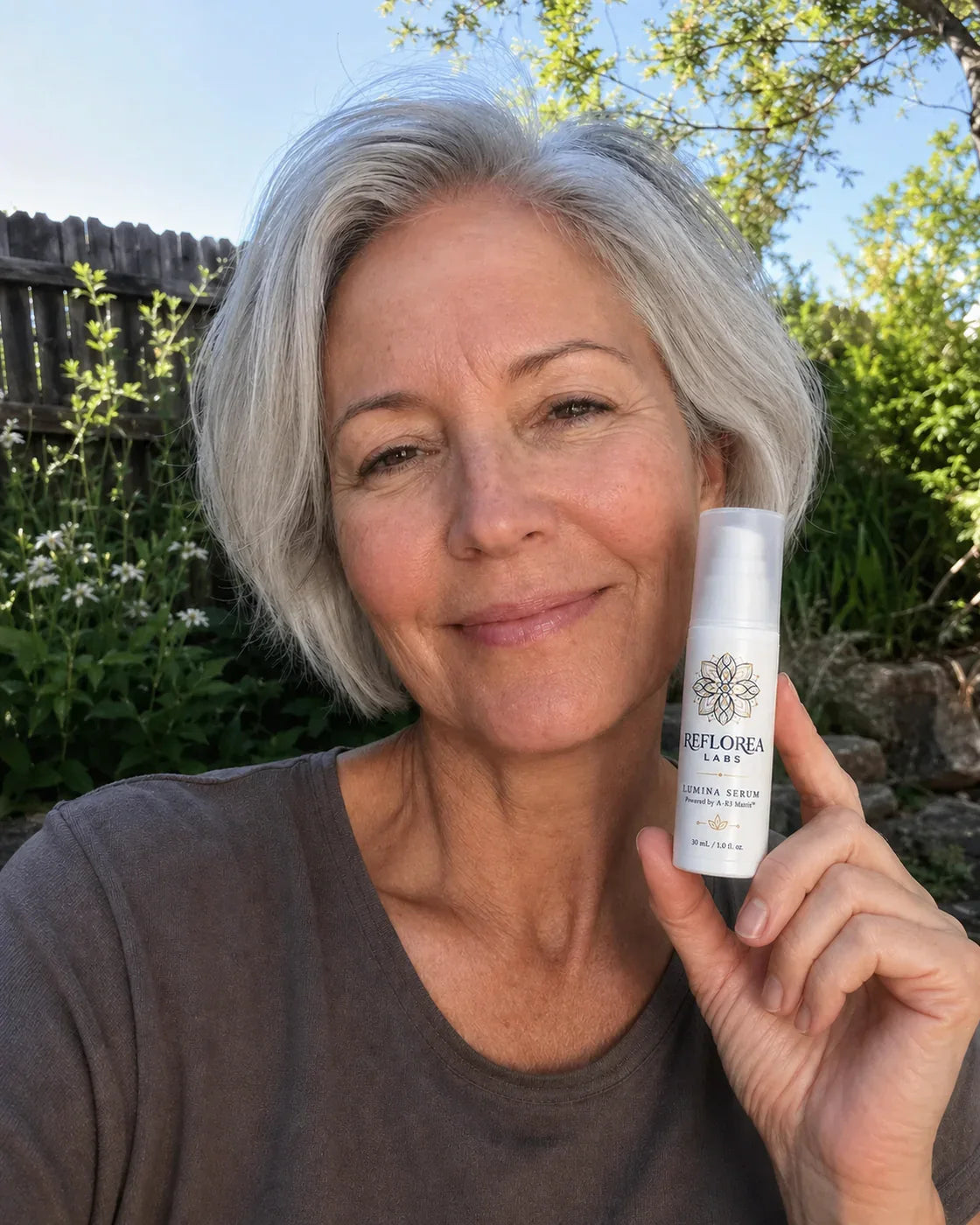 Woman holding the Lumina Serum bottle
