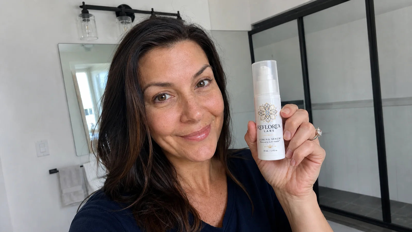 Woman holding the Lumina Serum bottle