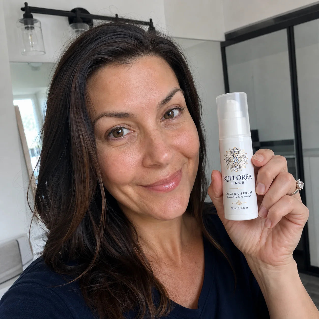 Woman holding the Lumina Serum bottle