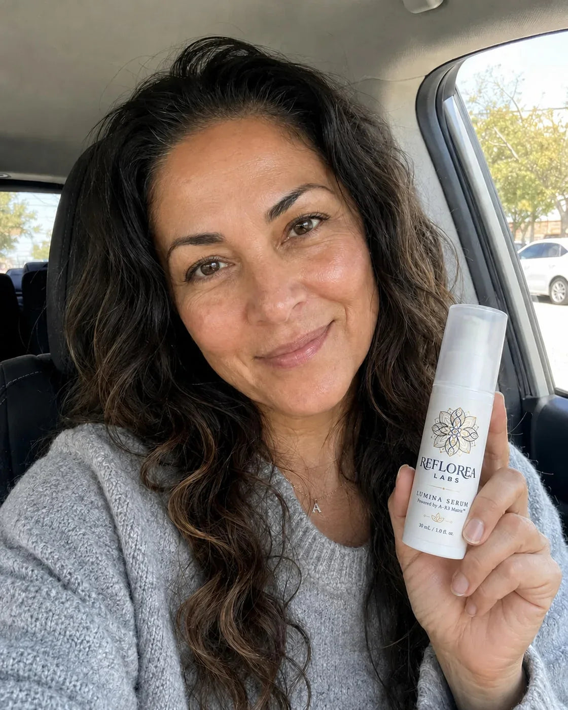 Woman holding the Lumina Serum bottle
