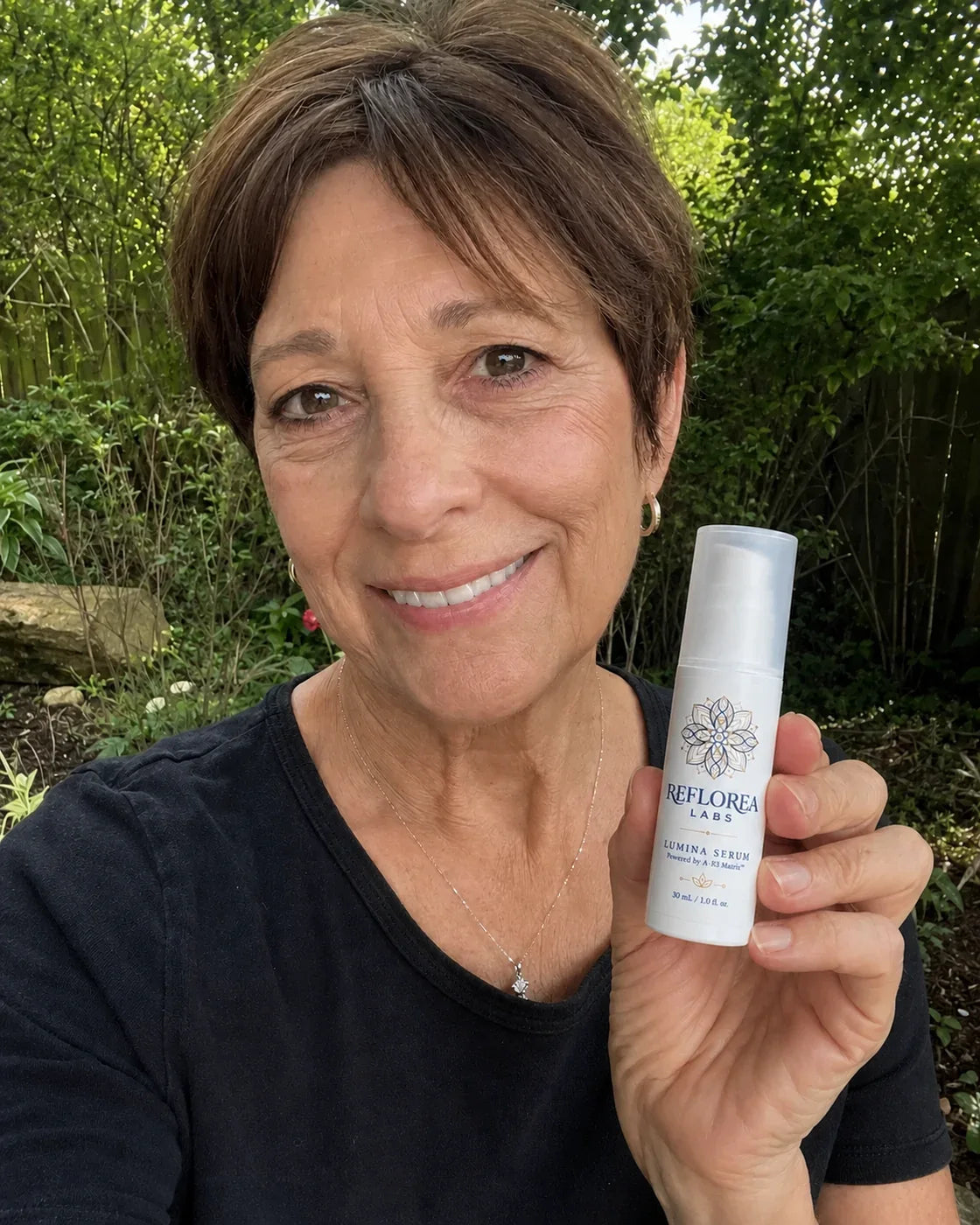 Woman holding the Lumina Serum bottle