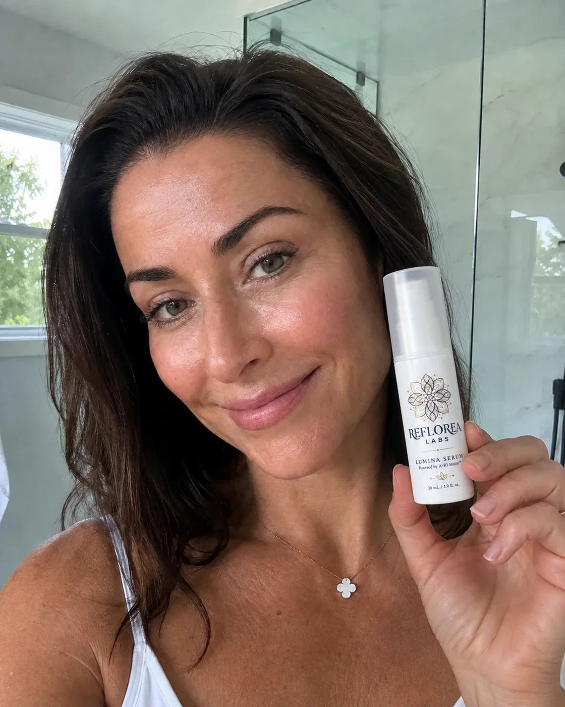 Woman holding the Lumina Serum bottle